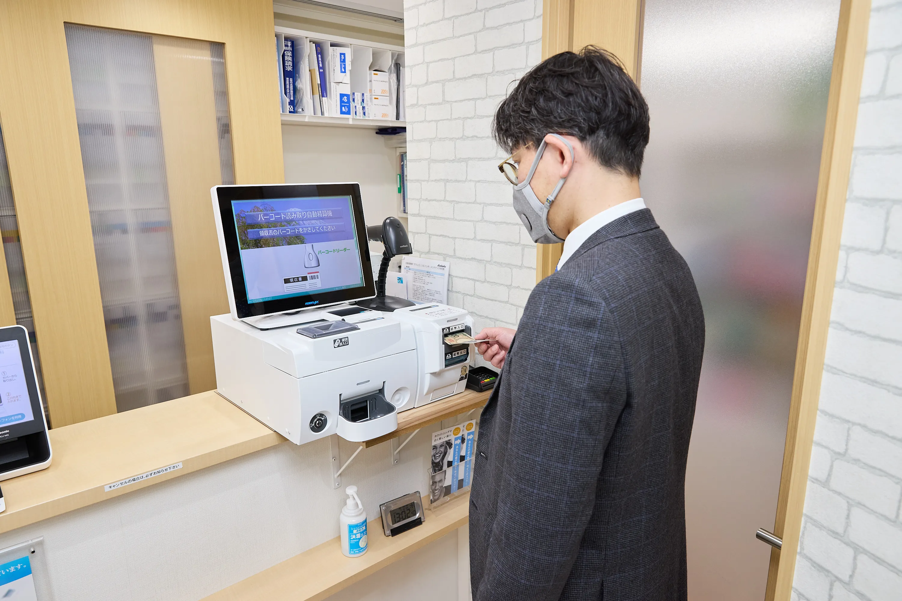 自動精算機デジレジを操作するいぬぶし歯科の会計シーン